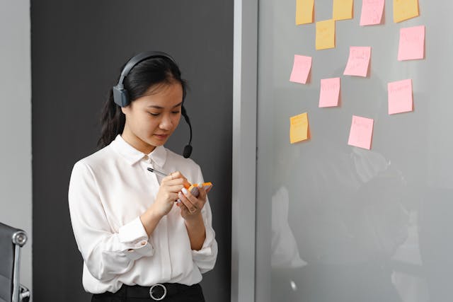 A woman writing on a sticky note
