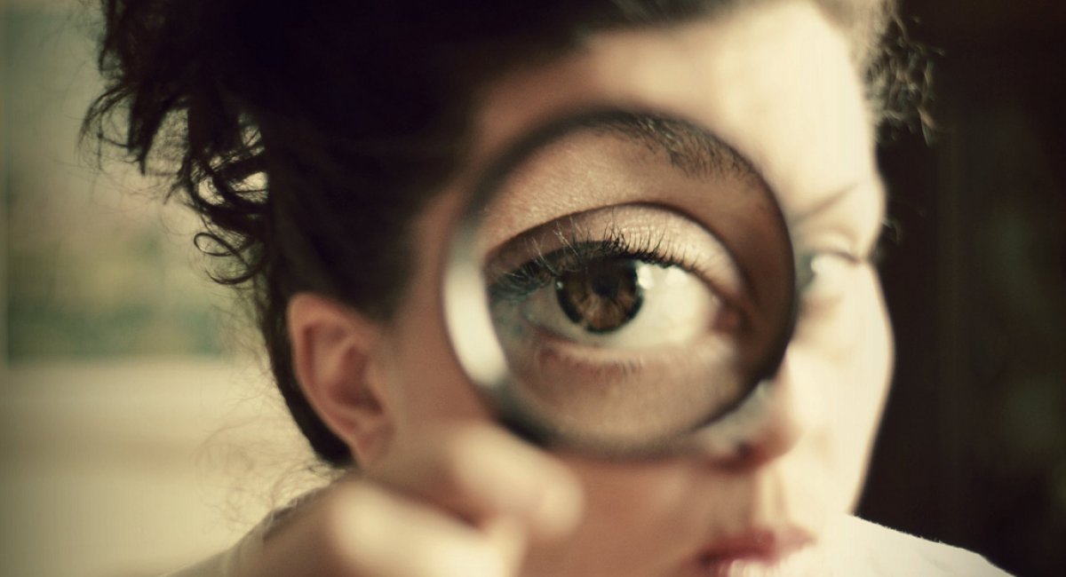 A woman looking through a magnifying glass