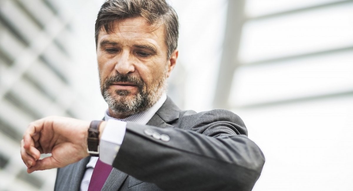 There's not enough time! Middle-aged businessman looking at his watch