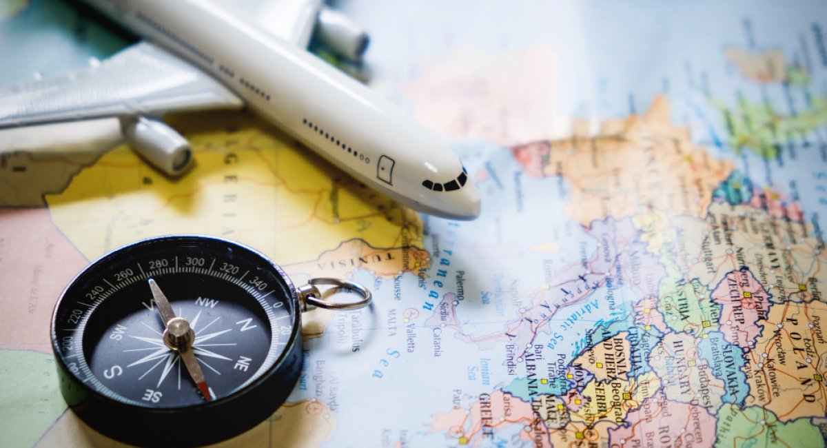 Compass and plastic toy airplane on a map 