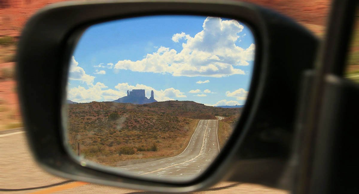 Looking back desert mountain seen in car rearview mirror