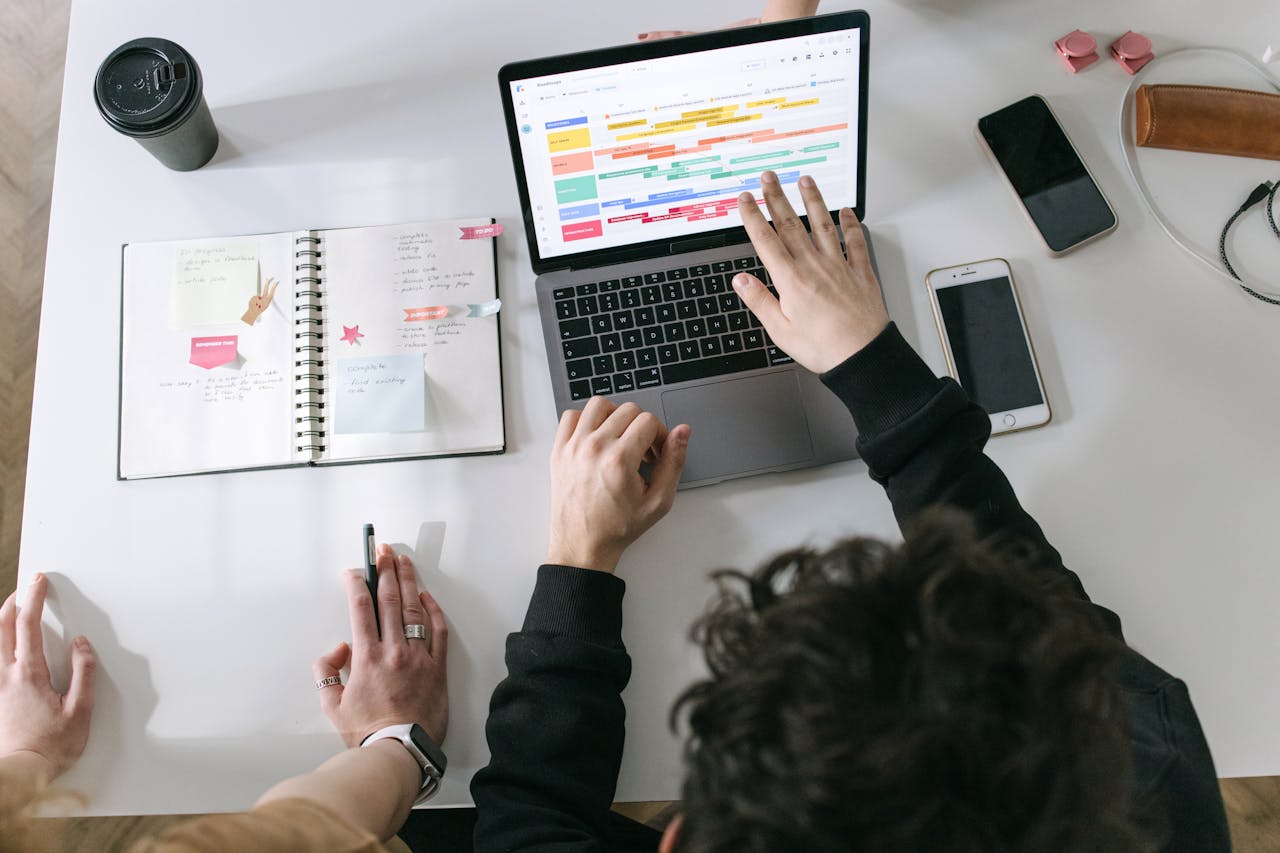 Two people looking at a schedule on a laptop