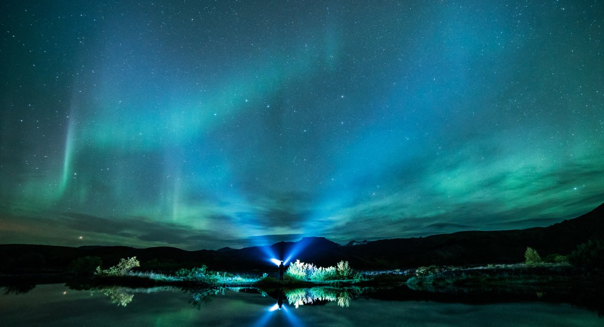 Green Aurora lights above body of water