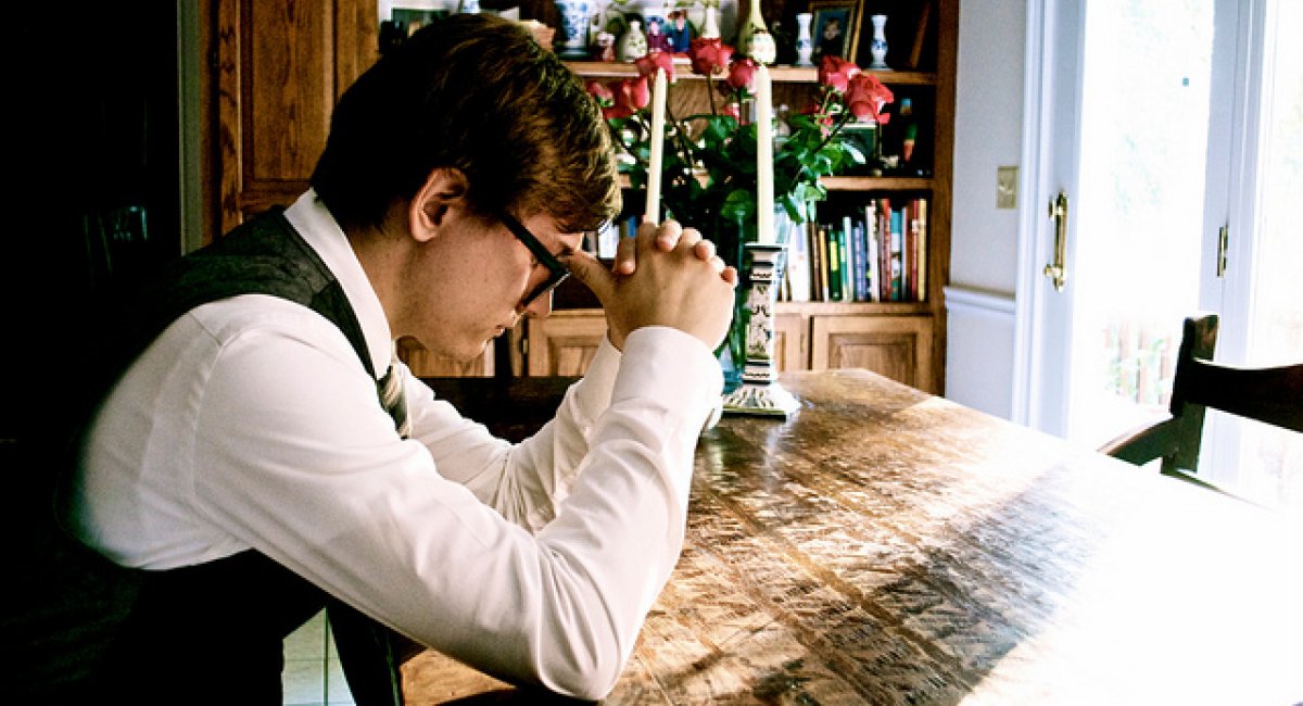 Man in thinking position with elbows on desk