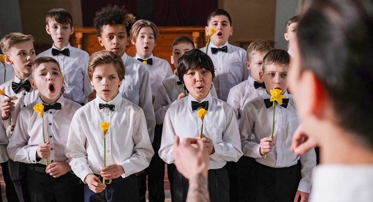 boys choir holding yellow flowers